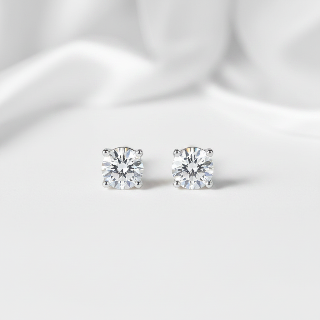 Pair of diamond stud earrings on a light fabric background