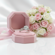 Silver ring in a pink jewelry box with pink and white roses in the background