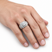 A close-up of a hand wearing a three-band diamond ring set in silver-toned metal, photographed against a clean white background.