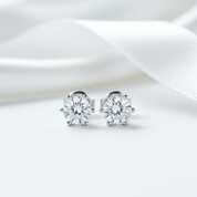 Pair of diamond stud earrings on a white satin background