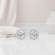Pair of diamond stud earrings on a light pink background