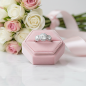 Diamond ring in a pink velvet box with flowers in the background