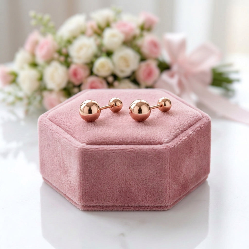 A pair of rose gold ball stud earrings with a polished finish, shown against a plain white background.
