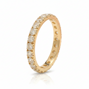 A yellow gold eternity ring featuring a half-channel setting of round brilliant-cut diamonds on a clean white background with a soft reflection.