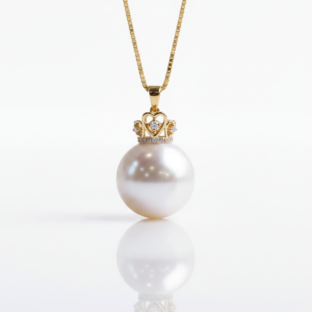A gold pendant necklace featuring a large, lustrous white pearl pendant under a small crown setting with tiny clear stones, suspended from a gold chain on a clean white background.