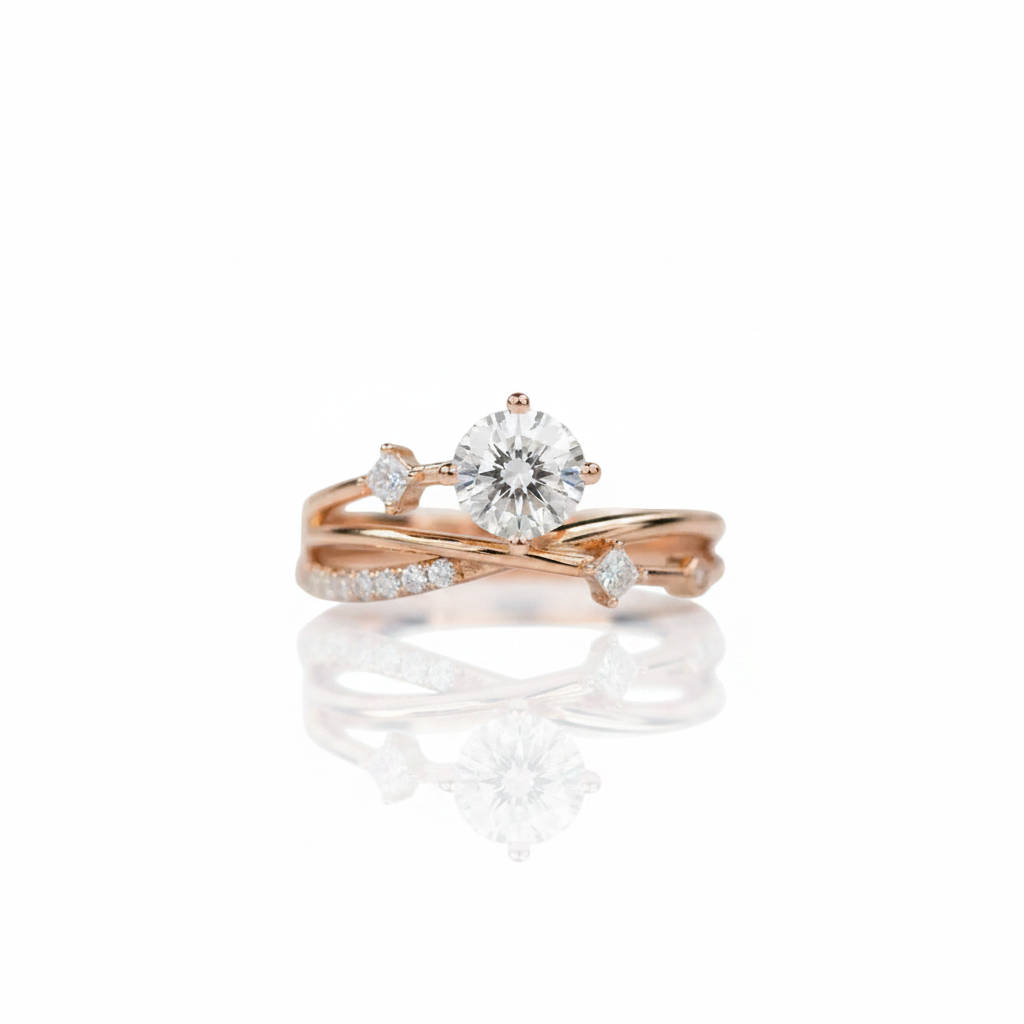 A rose gold engagement ring with a round brilliant-cut diamond center stone and smaller accent diamonds along the band, displayed on a clean white background with a soft reflection below.