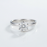 Silver ring with a diamond on a light gray background