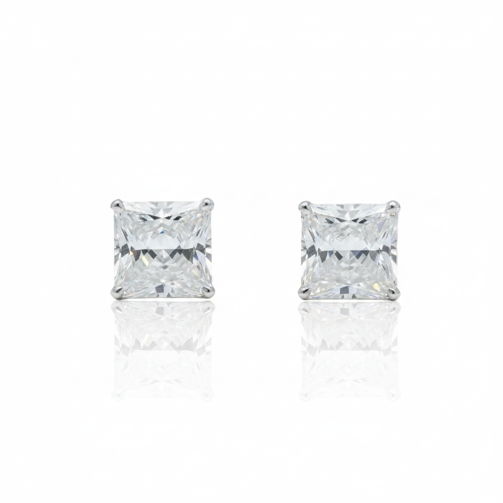 A pair of square stud earrings in rose gold, featuring a pavé setting of clear gemstones, shown on a white background with a soft reflection below.