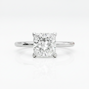 A radiant cut diamond solitaire engagement ring in a polished white gold or platinum band, centered on a clean white background with a soft reflection below.