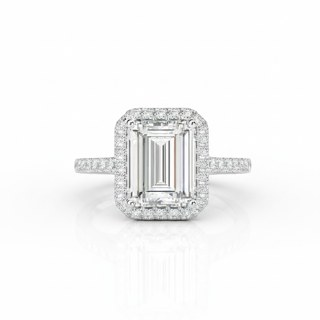 An emerald-cut halo ring featuring a central diamond surrounded by a double halo of smaller round diamonds, with a pavé band, set in a silver-colored metal on a white background.