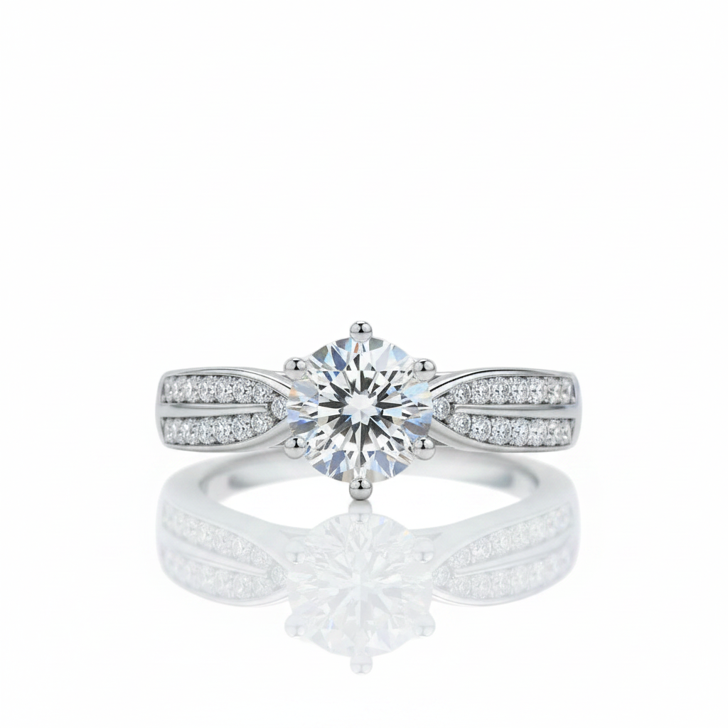 A silver-tone solitaire engagement ring with a round-cut center stone and pavé-set side stones, shown on a clean white background with a soft reflection below.