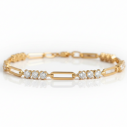 A yellow gold link bracelet featuring three rows of round-cut clear gemstones in the center, displayed on a clean white reflective surface.