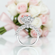Diamond ring with a heart-shaped center stone against a blurred floral background