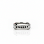 A silver-toned band ring with a row of small black round stones set along the front, photographed on a clean white background with a soft reflection below.