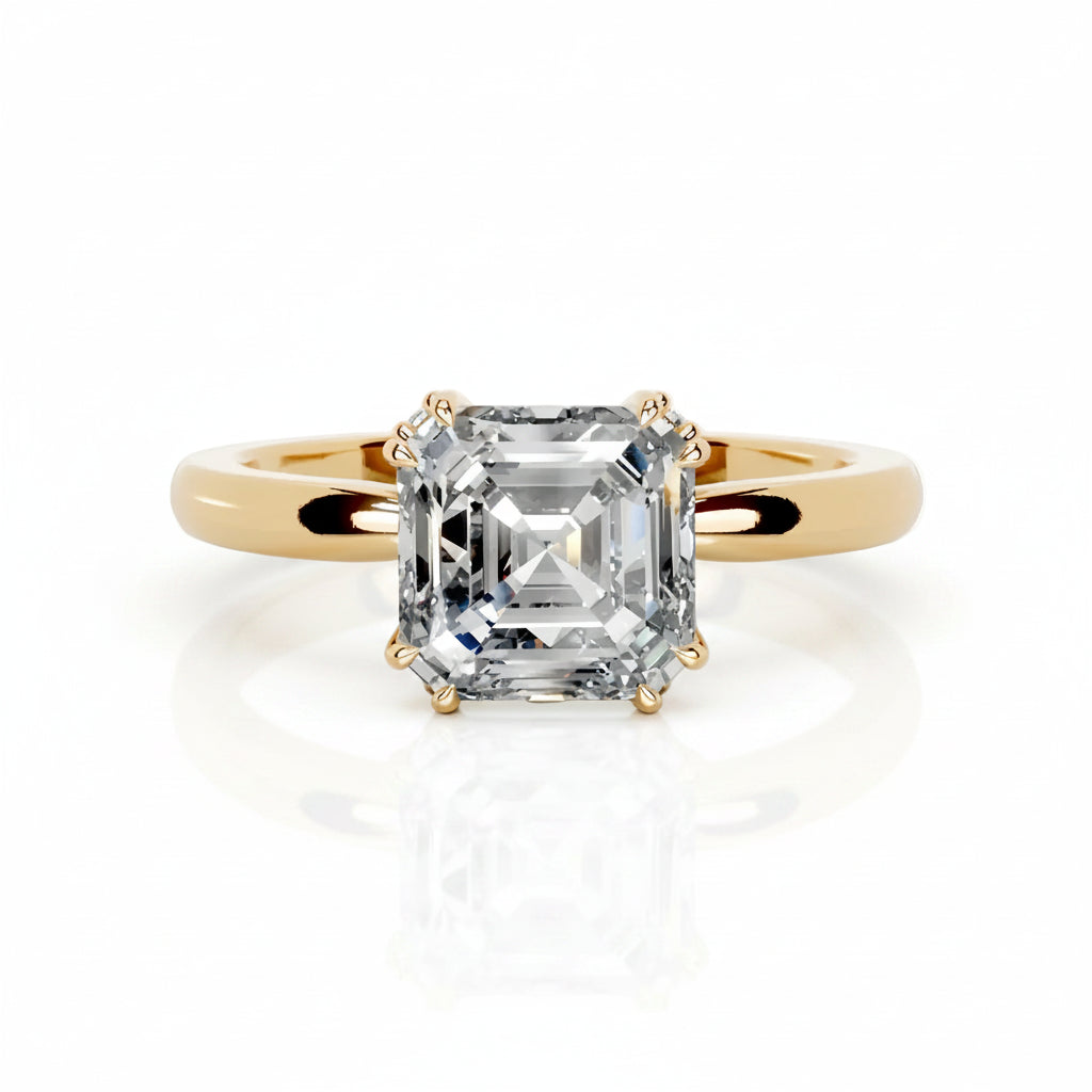 An emerald-cut diamond solitaire ring set in a yellow gold band, shown on a clean white background with a soft reflection below.