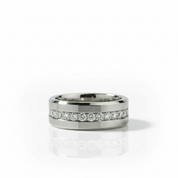 A silver-toned band ring featuring a channel-set row of clear round-cut gemstones along the center, photographed on a clean white background with a soft reflection below.
