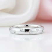 Silver ring with small diamonds on a white background
