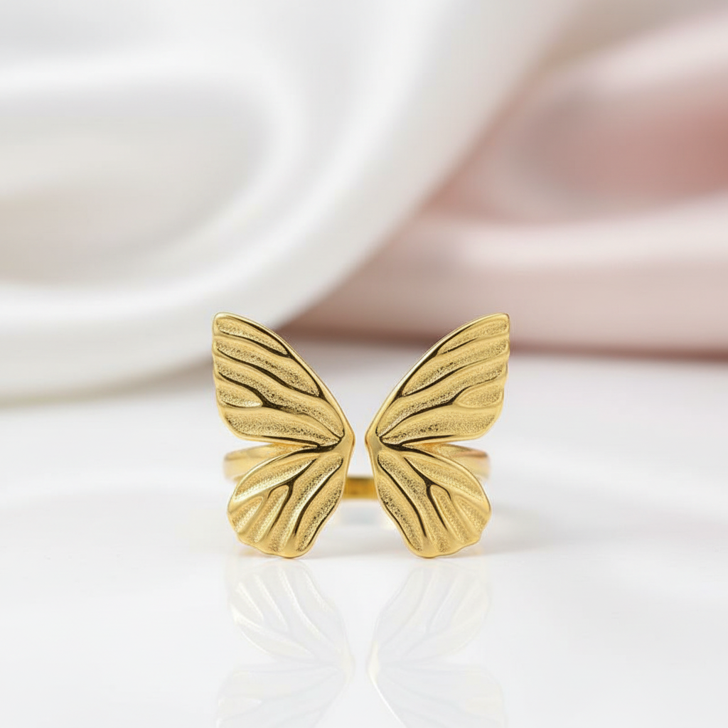 Gold butterfly-shaped ring on a white background