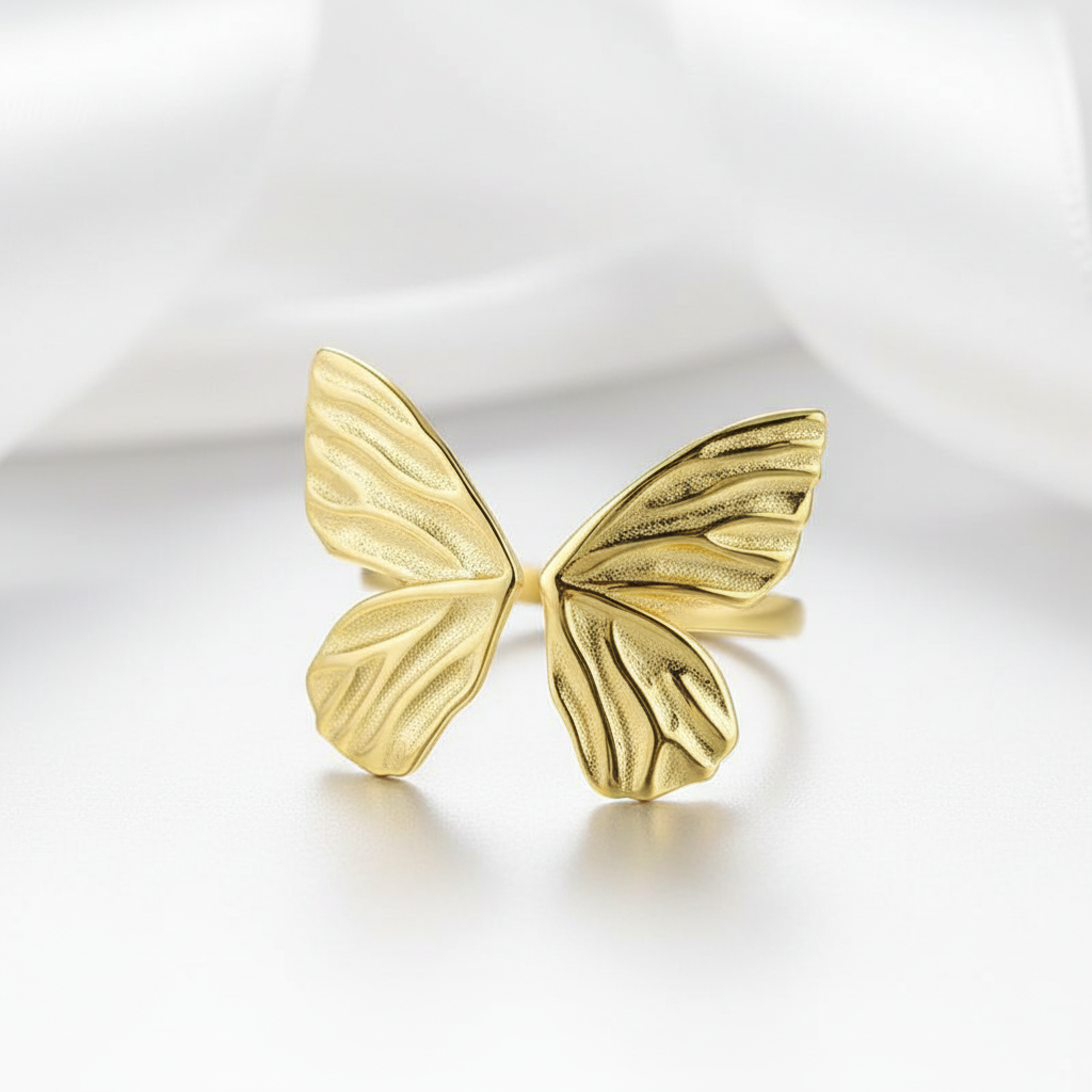 Gold butterfly-shaped ring on a white background