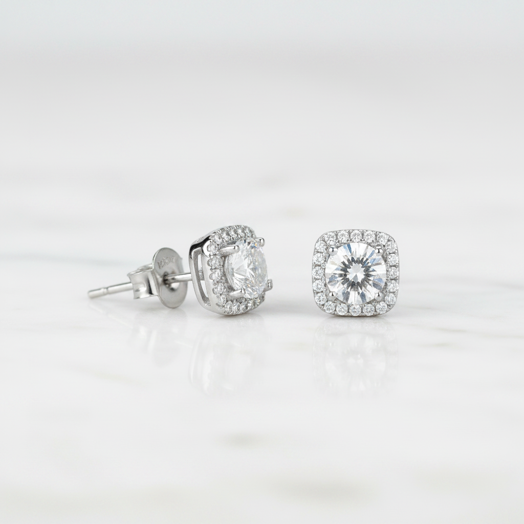 Silver stud earrings with clear gemstones on a light gray background