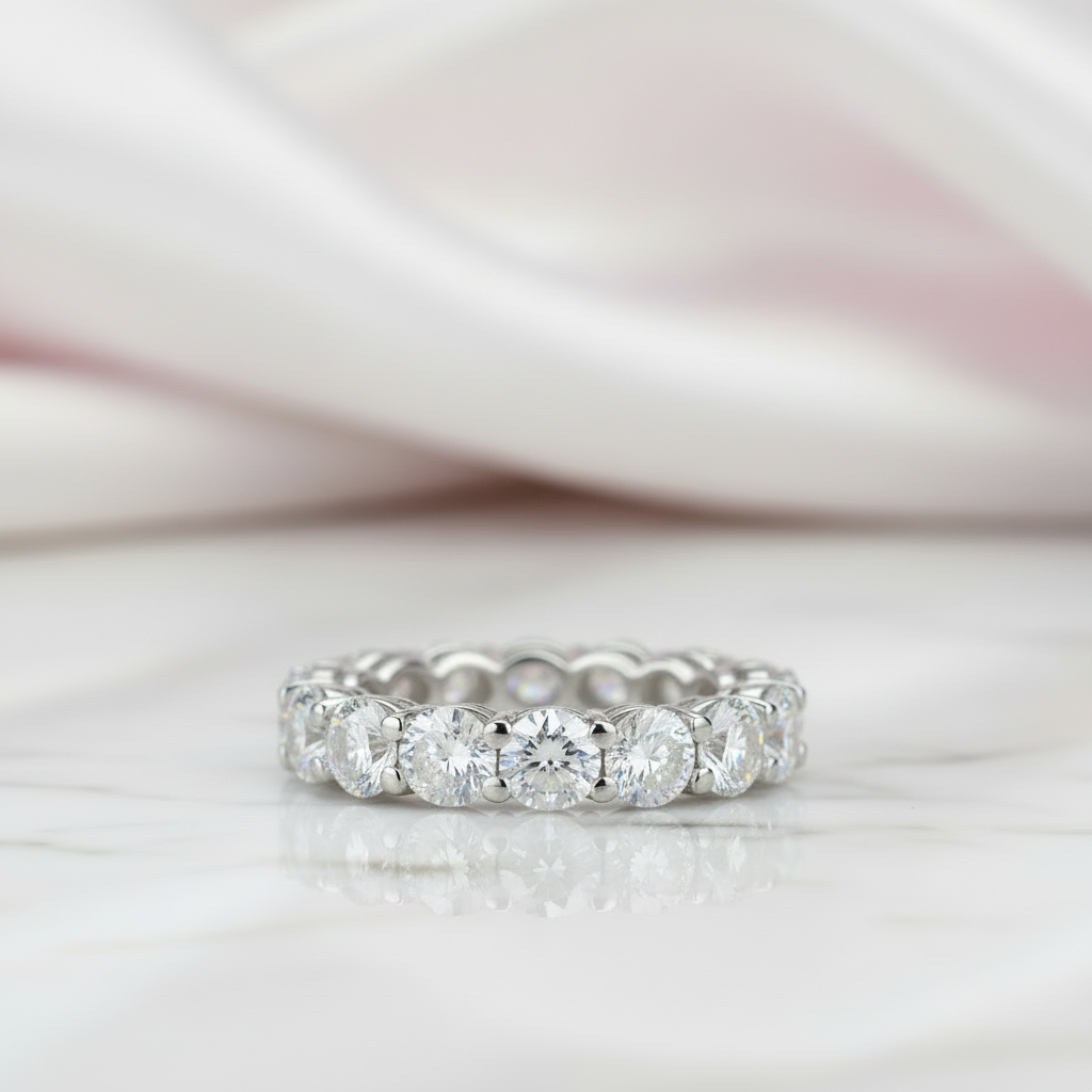 Silver ring with multiple diamonds on a soft pink fabric background