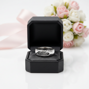 Silver ring in a black box with flowers in the background
