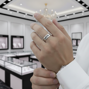 Hand wearing a silver ring in a jewelry store setting