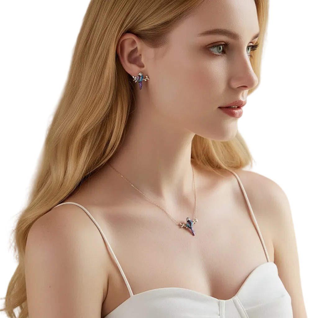 A woman in profile wearing a delicate silver-toned necklace and matching stud earring, both featuring a small blue and purple crystal starburst design. The brand name 'bamoer' is visible in the top left corner.