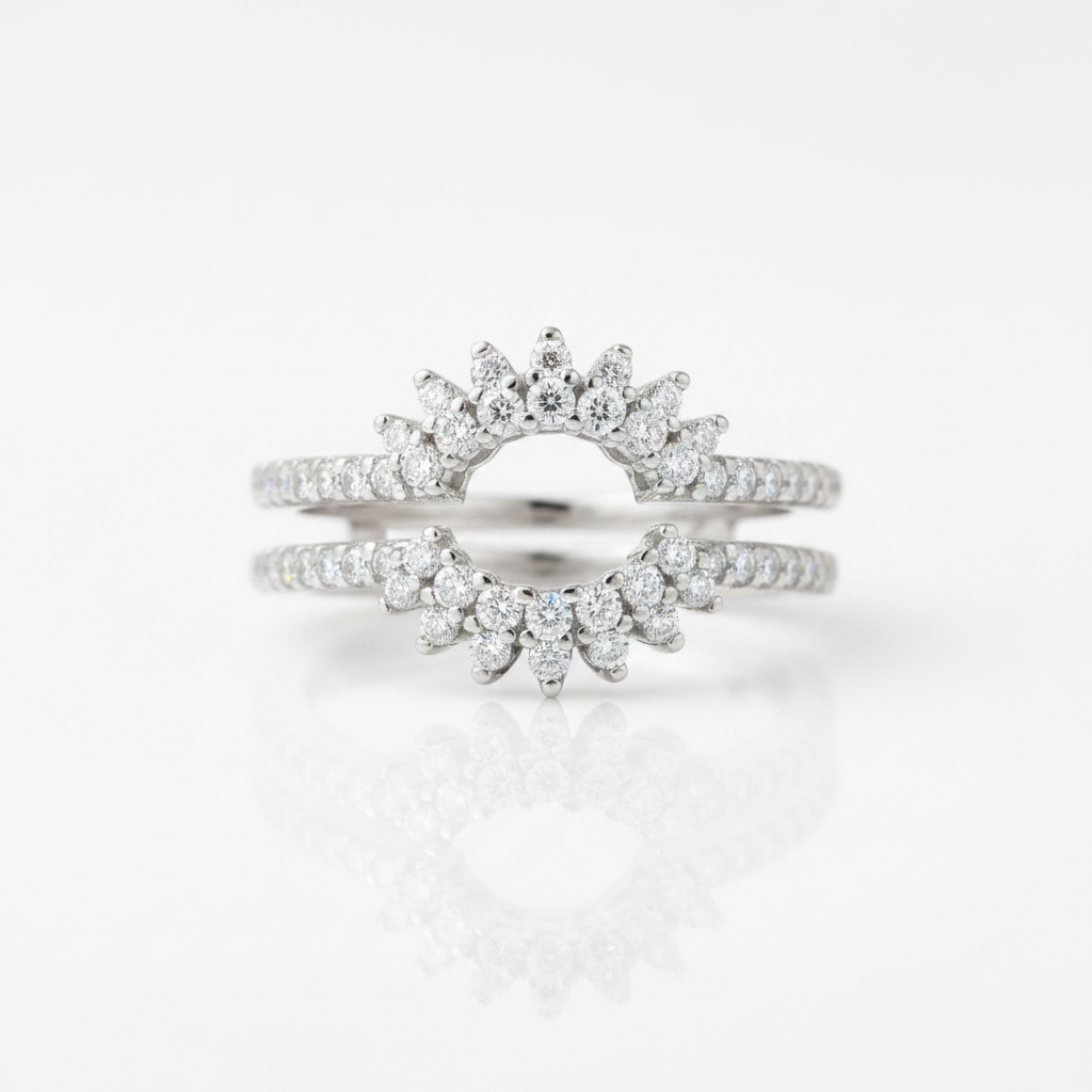 A pair of silver-toned wedding bands featuring a sunburst design set with marquise-cut and round diamonds, displayed on a clean white reflective surface.