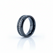 A black ceramic ring band featuring a channel-set row of clear cubic zirconia stones, displayed on a clean white reflective surface.