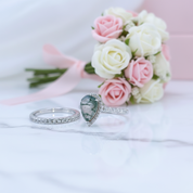 Two rings with a bouquet of pink and white roses on a light background
