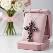 Decorative cross necklace on a pink stand with flowers in the background
