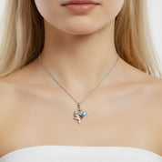A close-up of a model wearing a delicate silver-toned necklace with a small mermaid charm adorned with light blue and white crystals.