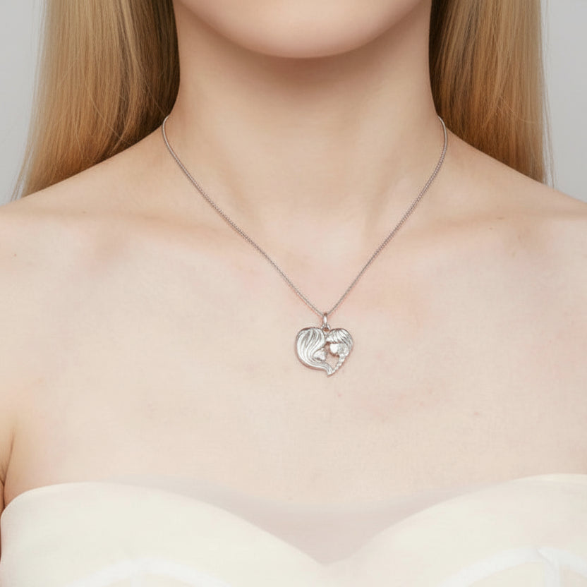 A close-up of a woman's neck and upper chest wearing a delicate silver chain necklace with a heart-shaped pendant featuring a small rose gold heart in the center.