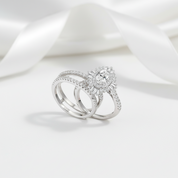 Two silver rings with diamond accents on a white fabric background