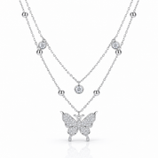 A silver-tone double-layer necklace featuring a delicate chain with small bead accents and round bezel-set clear stones, and a larger chain with a butterfly pendant paved with clear stones, shown on a white background.