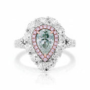 A pear-cut diamond ring with a halo of small pink diamonds and a white gold or platinum setting, photographed on a clean white background.