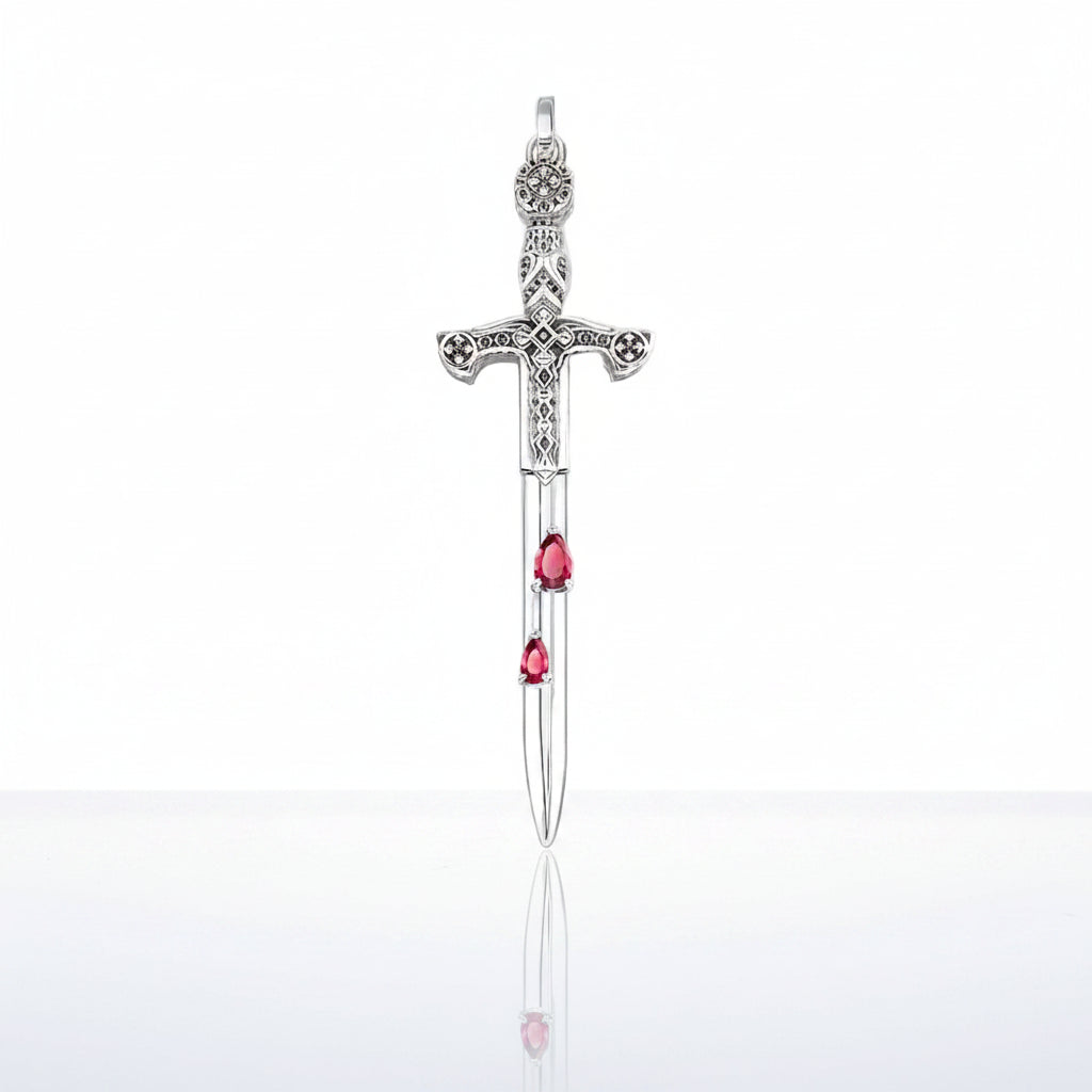 A silver sword pendant featuring three small teardrop-shaped pink gemstones along the blade, displayed against a clean white background with a soft reflection below.