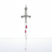 A silver sword pendant featuring three small teardrop-shaped pink gemstones along the blade, displayed against a clean white background with a soft reflection below.
