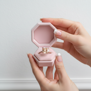 Diamond ring in a pink hexagonal box with flowers in the background