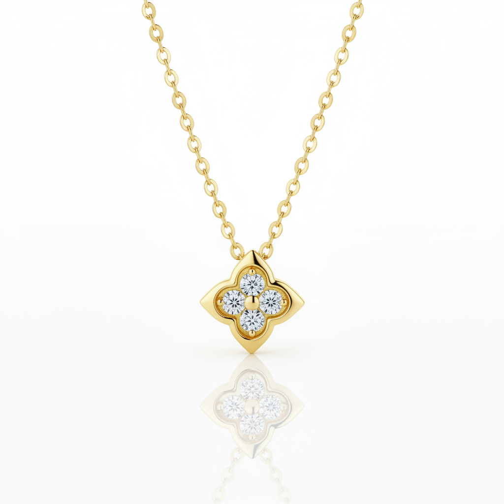 A gold necklace with a four-petal flower pendant set with clear round-cut gemstones, displayed on a clean white background with a soft reflection below.
