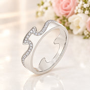 A silver-tone ring with a wavy, stylized design set with small clear stones, shown on a white background with a soft reflection. The brand logo 'MINTY BOX' is visible in the top left corner.