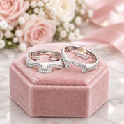 Two silver rings with intricate designs on a lace fabric background