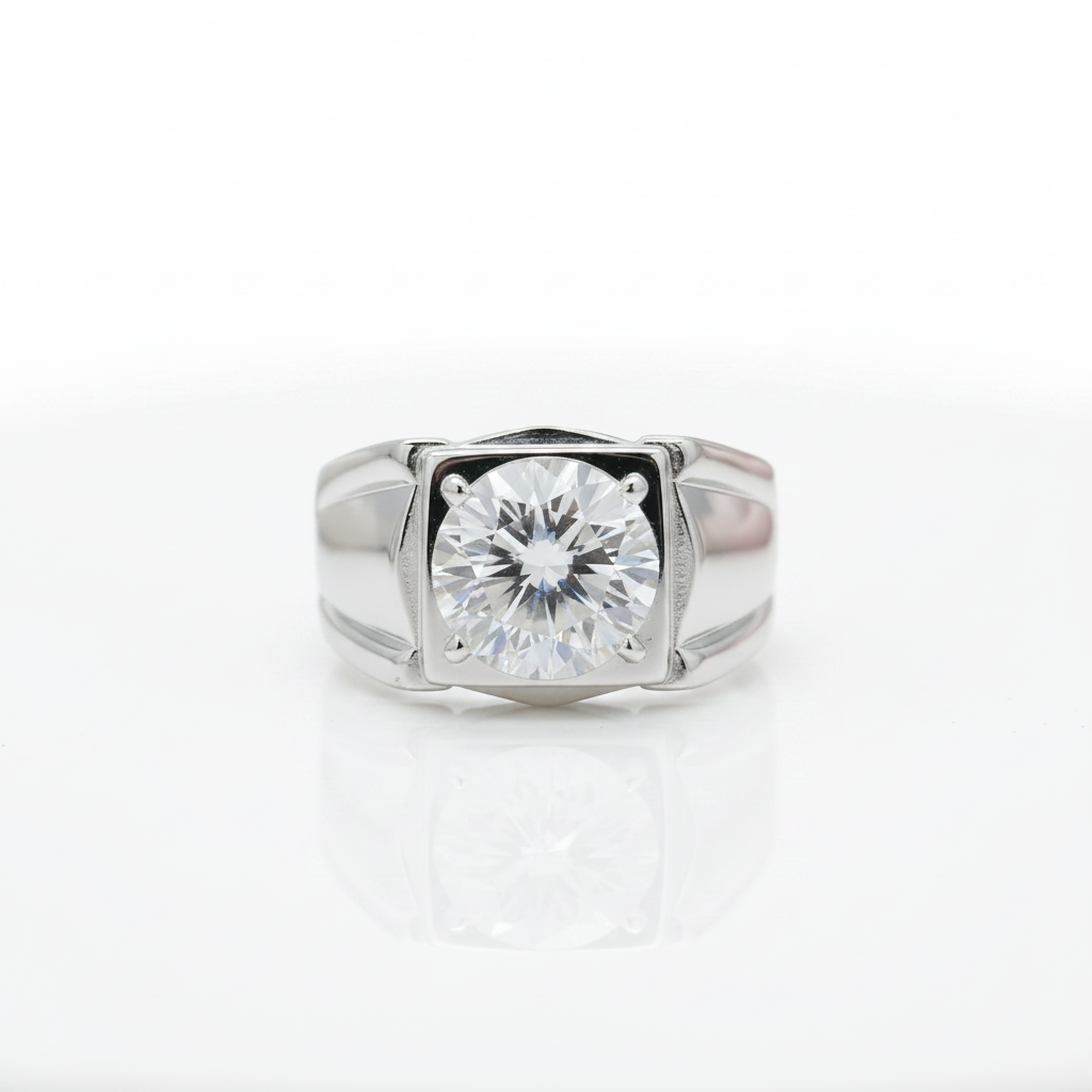 A silver-toned ring featuring a large round brilliant-cut gemstone in a square bezel setting, photographed on a clean white reflective surface.