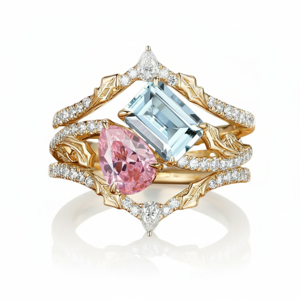 A luxury multi-band ring featuring a large light blue emerald-cut center stone, a pink pear-cut accent stone, and a small diamond, set in gold and white gold bands paved with clear diamonds, on a white background with a soft reflection.