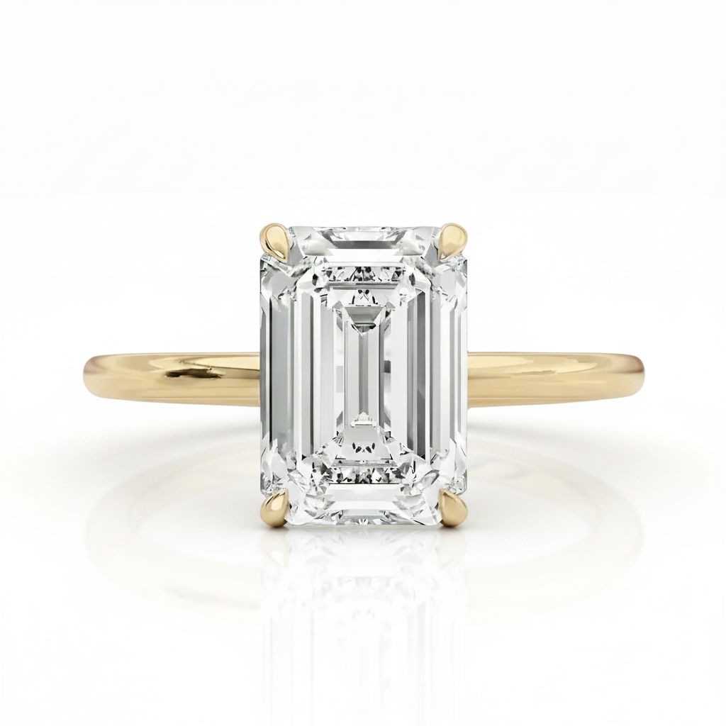 An emerald-cut diamond engagement ring with a yellow gold band, shown on a clean white background with a soft reflection.