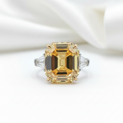 Ring with a large rectangular yellow gemstone on a white background