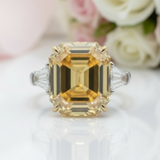 Gold ring with a large diamond in front of flowers