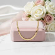 Pink jewelry box with gold handle in front of pink and white roses