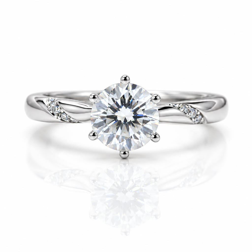 A silver-toned solitaire engagement ring with a round brilliant-cut center stone and small accent stones on the band, shown on a clean white background with a soft reflection below.